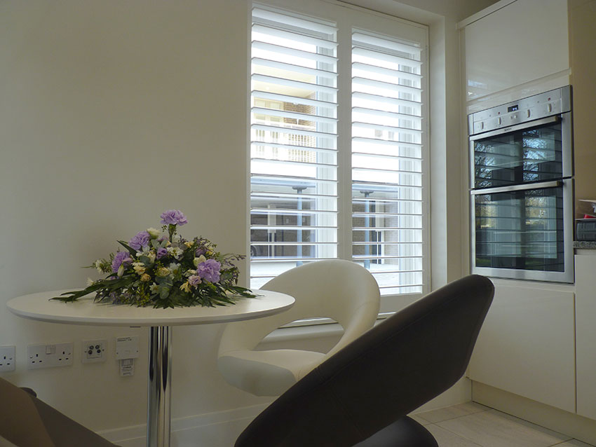 White Plantation Shutters With Big Louvre Blades In Kitchen Window