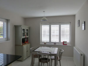 White Plantation Shutters Across Two Windows In Kitchen Diner