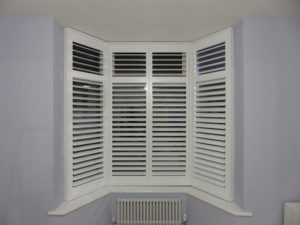 Tall Angled Bay Window With White Shutters