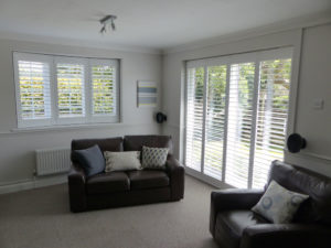 White Shutters In Shallow angled Bay Window and French Doors In Living Room