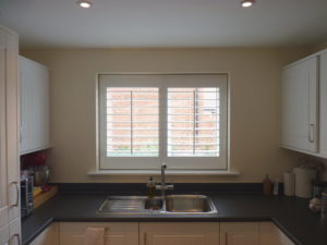 White Louvered Shutters In Kitchen Window