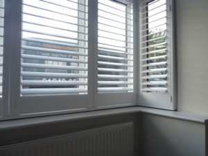 Close Up Of White Shutters In Square Bay Window