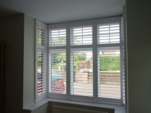 White Wooden Shutters In Square Bay Window