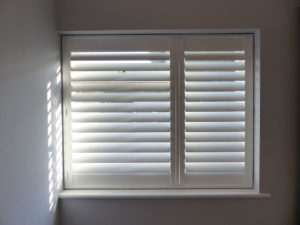 White Plantation Shutters With One Wide Panel And One Slim